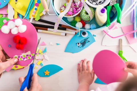 Child and adult hands cutting paper