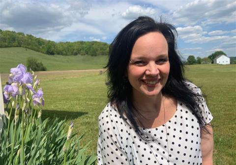 Wendy Koile standing by an iris flower in the countryside