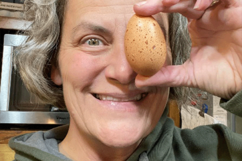 woman holding an egg in front of her face