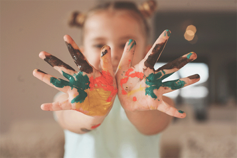 toddler with paint on her hands