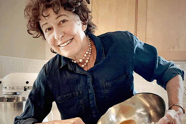 Ruth Pangrace performing as Julia Child in a kitchen setting