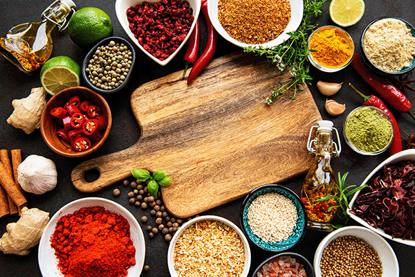 spices surrounding a cutting board