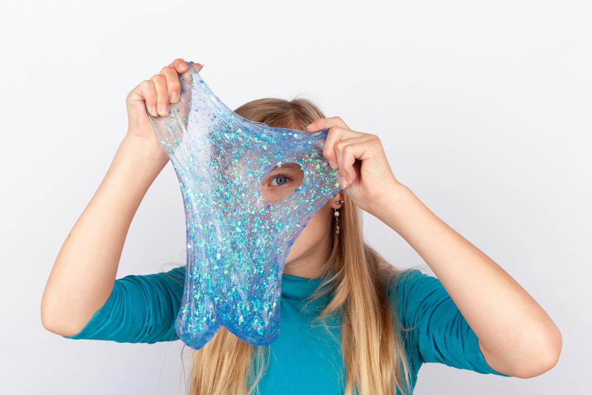 young girl looking through blue slime